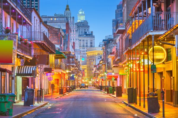 A vibrant street scene with colorful buildings and neon lights, capturing the lively atmosphere of a city at twilight.